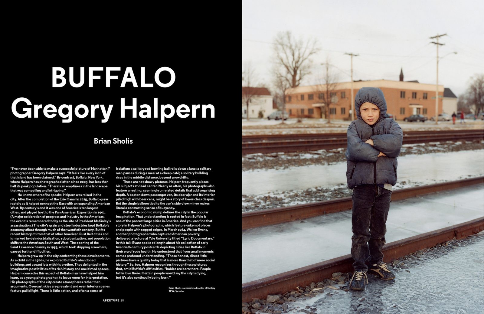 A spread from a magazine with text on the left-hand page and a portrait of a young boy standing with his arms crossed near icy train tracks on the right.